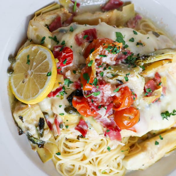 Bacco Bistro's creamy pasta dish with chicken, artichokes, tomatoes, and a lemon slice.